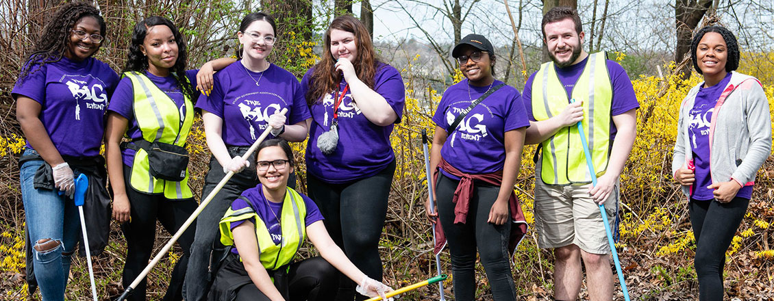 Students holding rakes during a community clean-up event