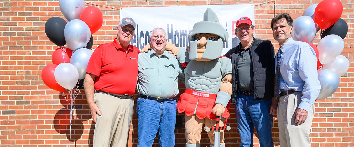 Four male alumni at the homecoming alumni party