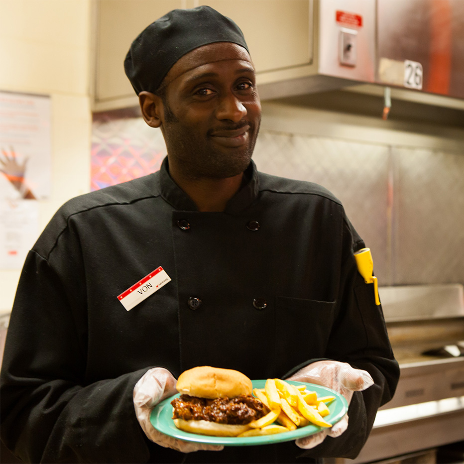 Chef serving meal at dining hall