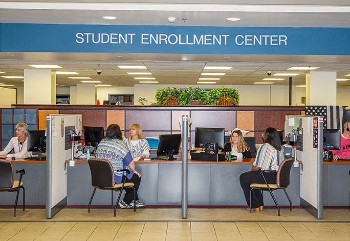 Students speaking with staff in the Student Enrollment Center lobby