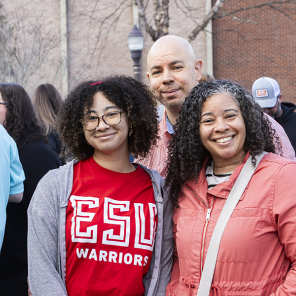 Student standing with parents