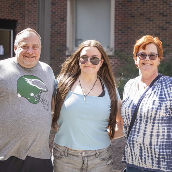 Student standing with family